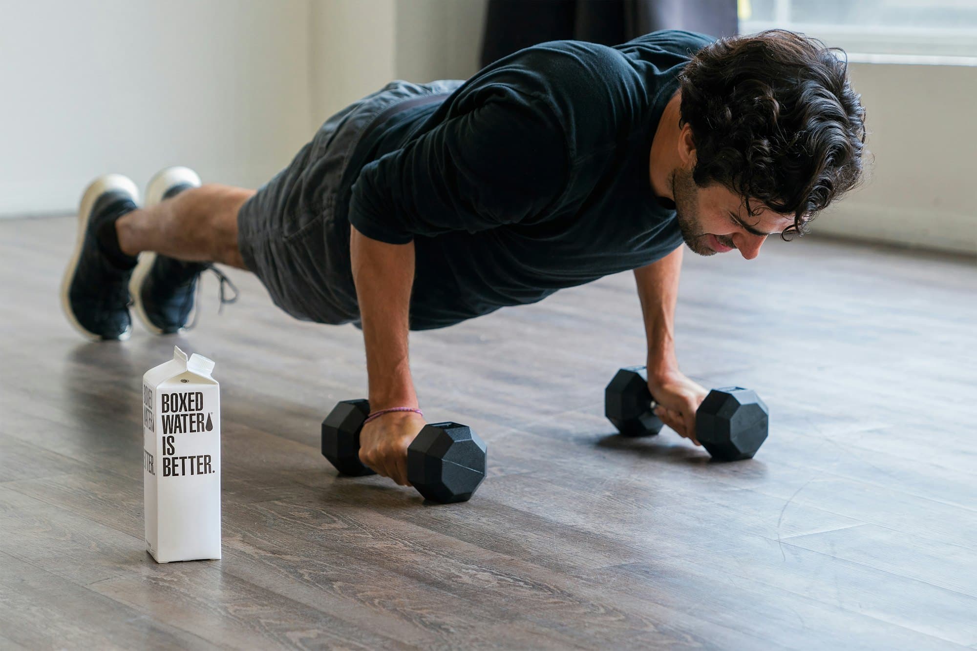 Man doing push-ups on a pair of dumbbells